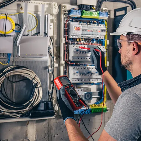 Elektroinstallateur bei der Prüfung eines Schaltschranks